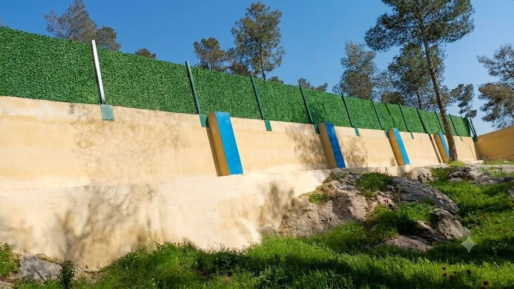 سور حجري مع ساتر أخضر